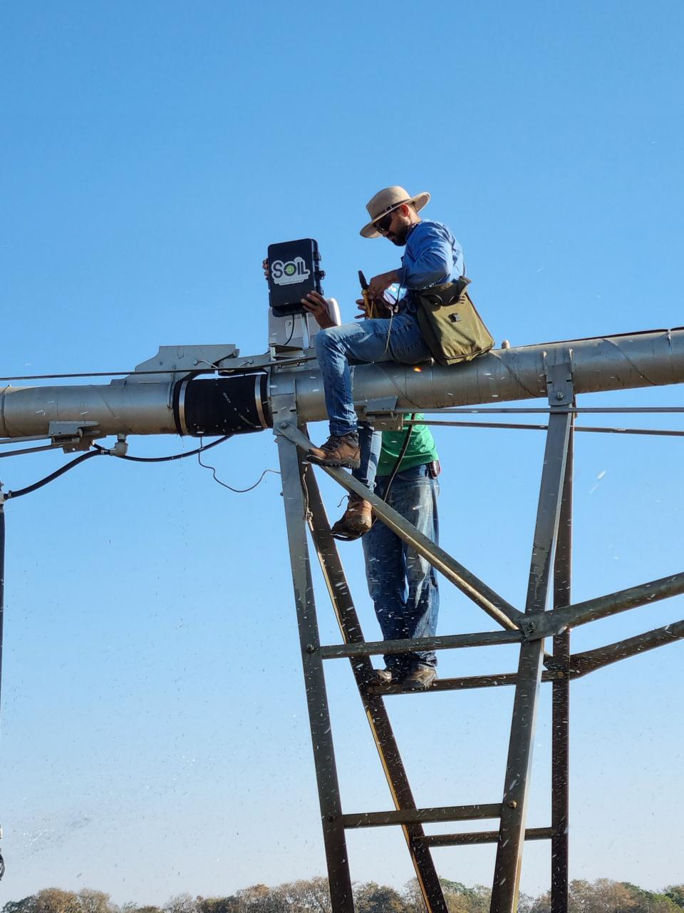 Funcionários da Soil instalando um monitor de controle em um pivô de irrigação.